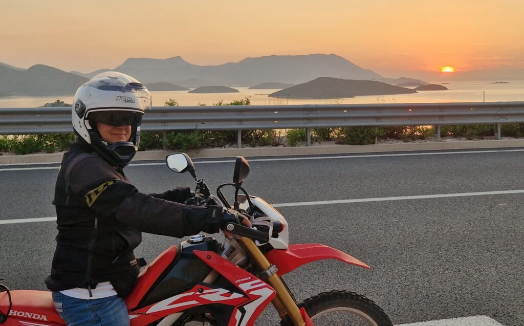 woman on a dualsport motorcycle at sunset